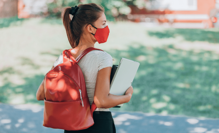 Student with mask and books