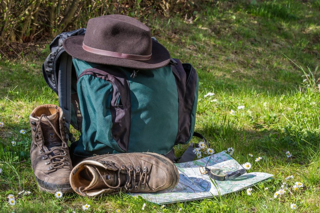 backpack, hiking boots, a hat, and compass