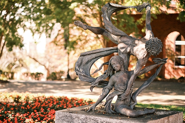 Statue of two dancers on college campus