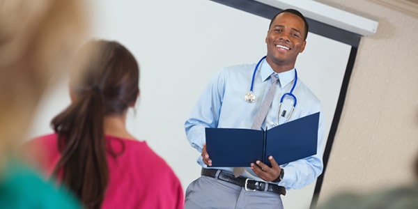 Male nurse educator speaking to classroom of college students