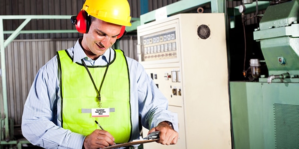 Occupational health and safety specialist writing on clipboard