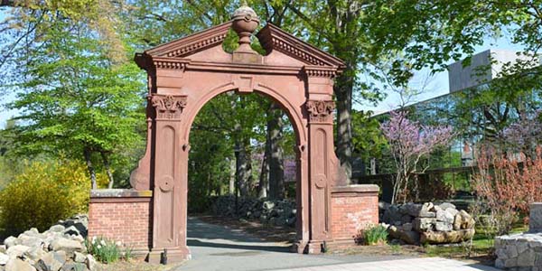 Outdoor view of college campus with rustic arch