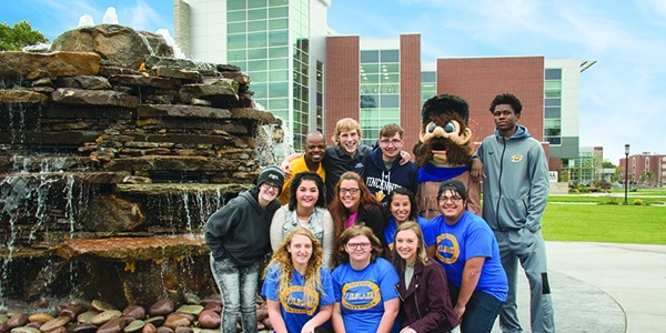 College students posing with mascot on campus