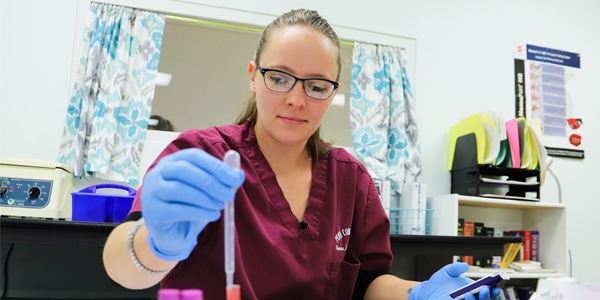 Healthcare student holding vial with liquid