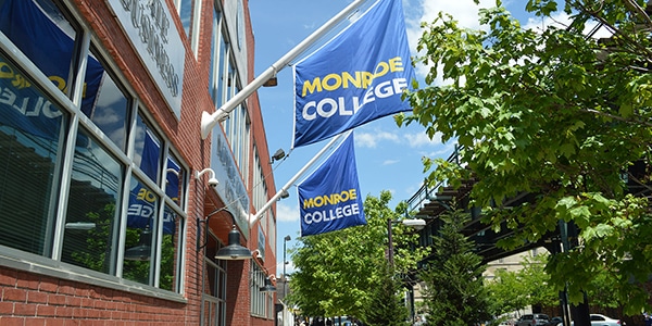 Monroe College flags hanging from college building
