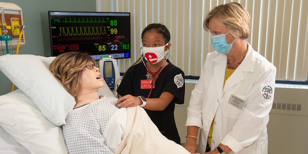 Nursing student and professor treating dummy patient