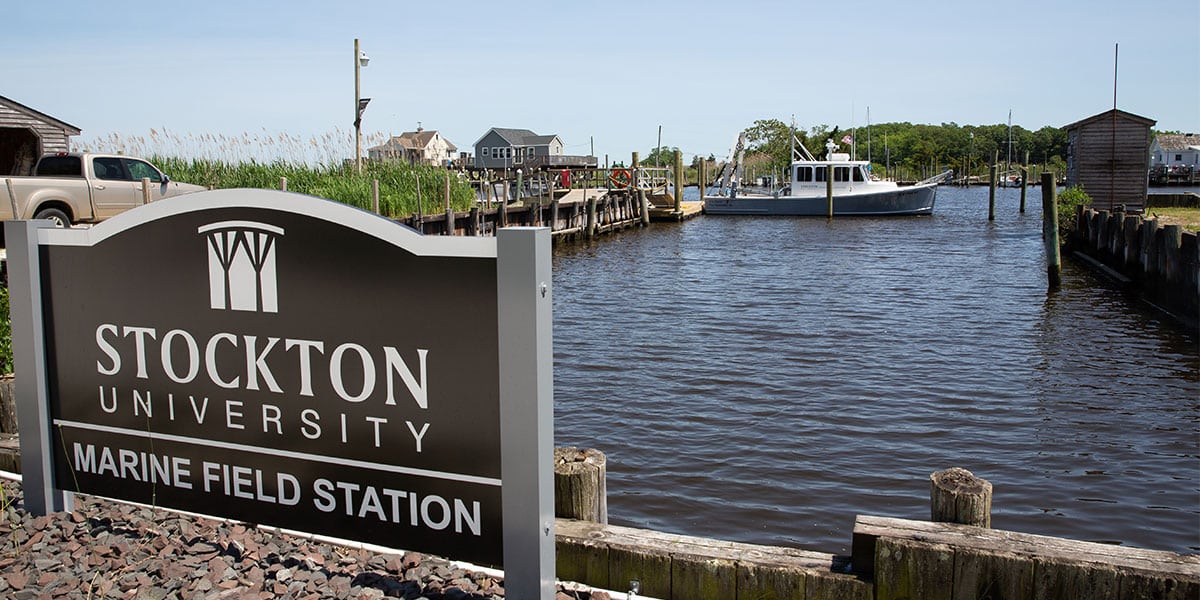 Stockton University Marine Field Station sign and marina with boats