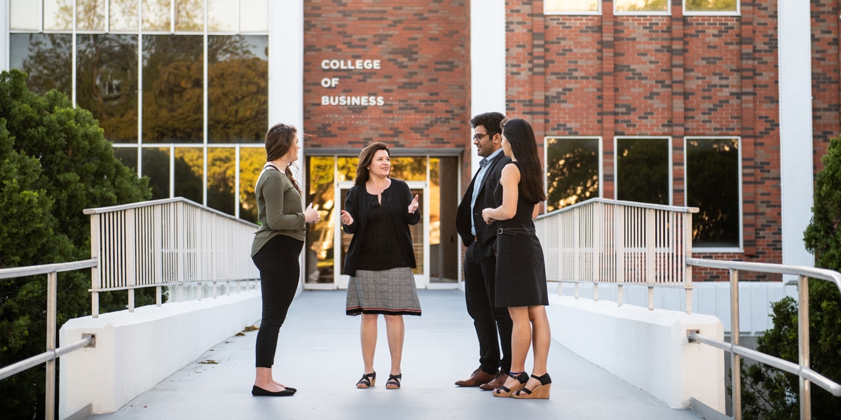 Students and facult talking outdoors on college campus