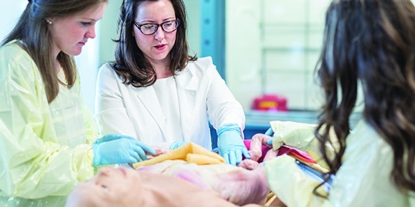 Nursing students and professor treating dummy patient