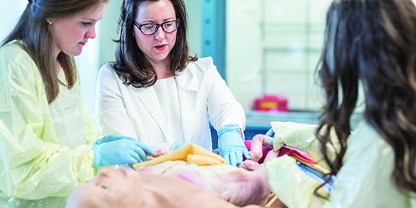 Nursing students and professor treating dummy patient