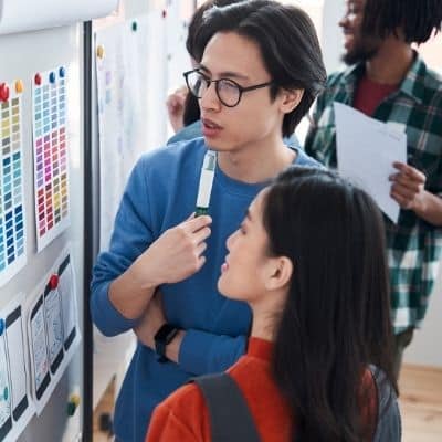 College students looking at printed color swatches on whiteboard