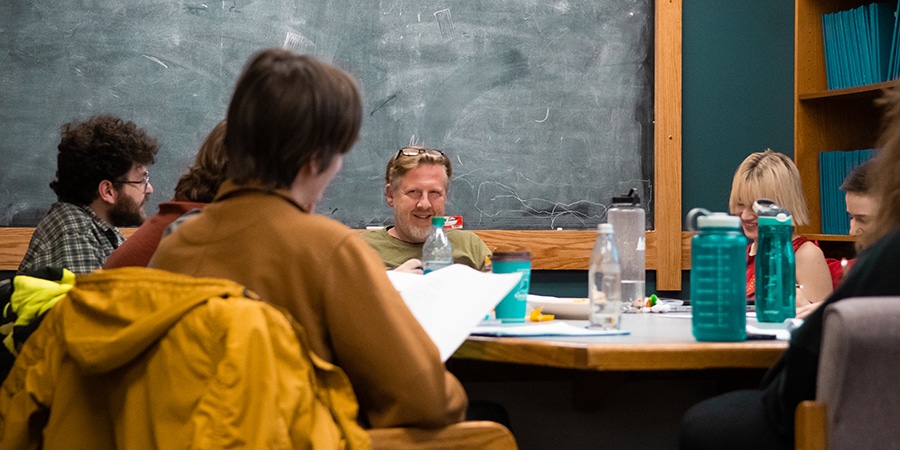 College students and professor sitting around a table