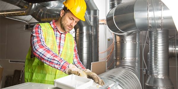 HVAC technician working with ductwork