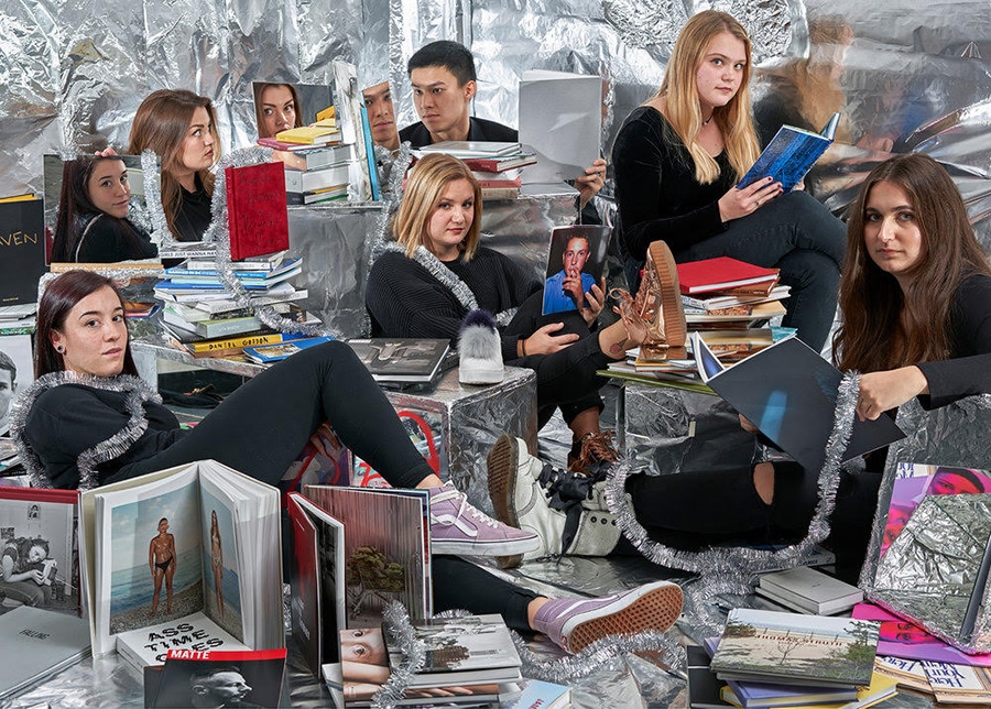 Group of students sitting on the floor surrounded by magazines