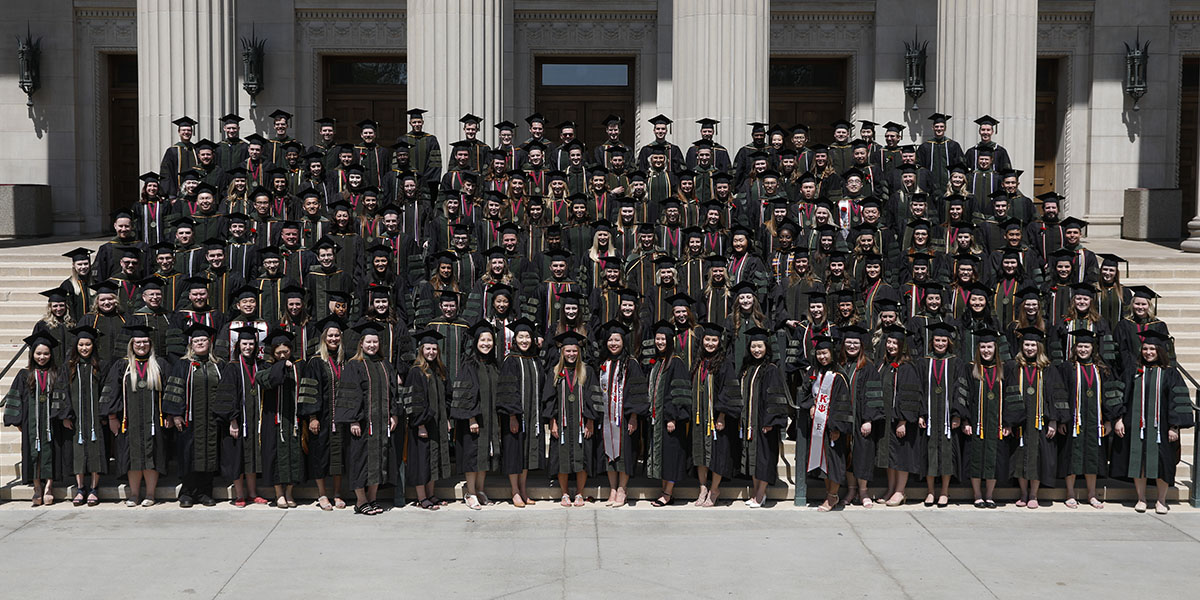 Graduating class standing on steps of building