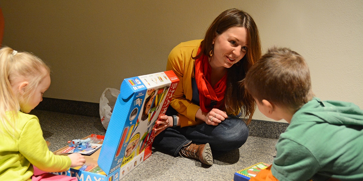 College student playing games with young children