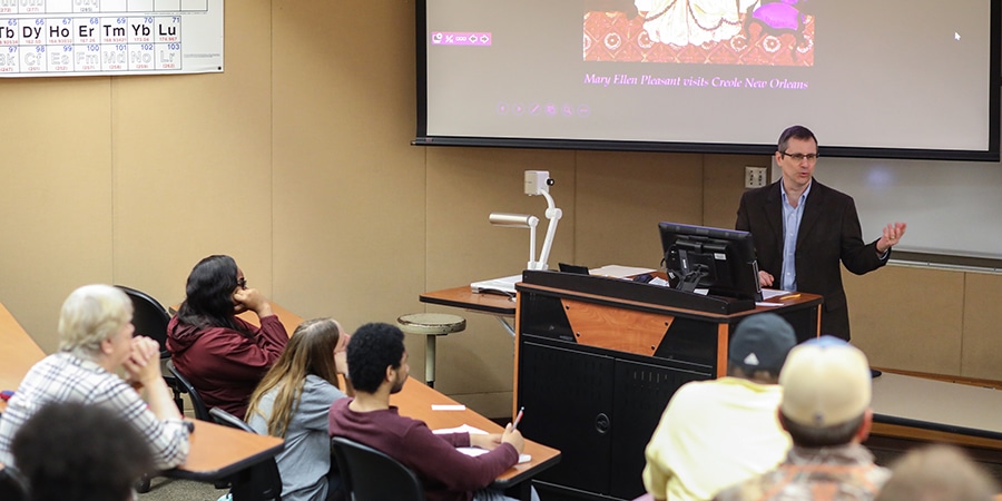 College professor lecturing to classroom of students