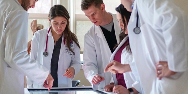 Healthcare professionals looking at digital table screen