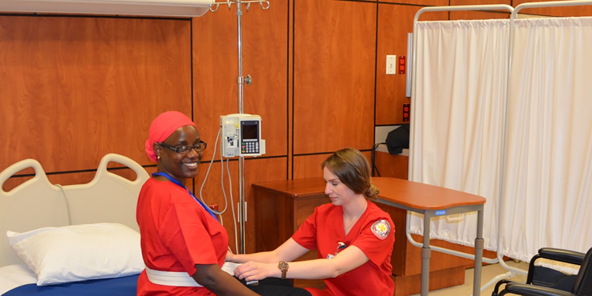 Nursing students at mock hospital room