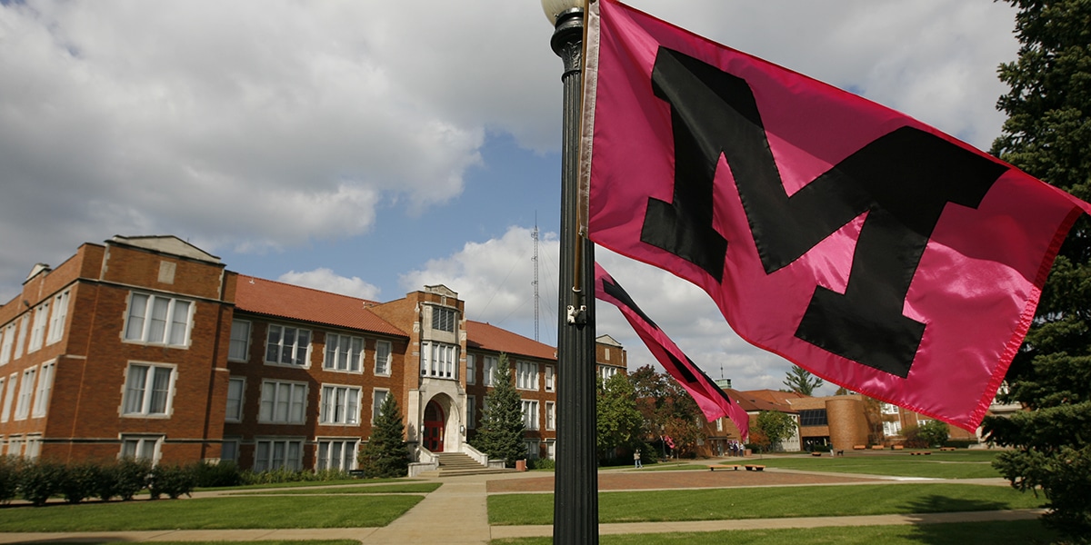 Outdoor view of college campus and flag hanging from pole