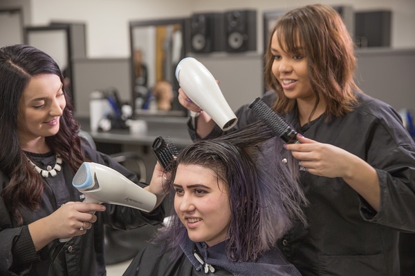 Students styling woman's hair