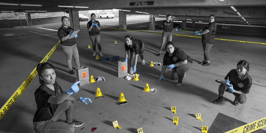 Students observing a mock crime scene in parking structure