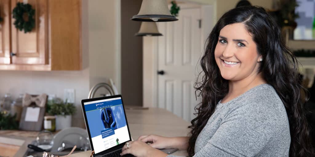 University of West Florida college student sitting at the table with a laptop