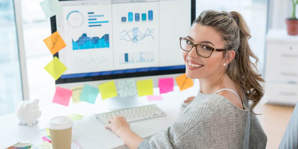 Female business professional smiling and working at computer