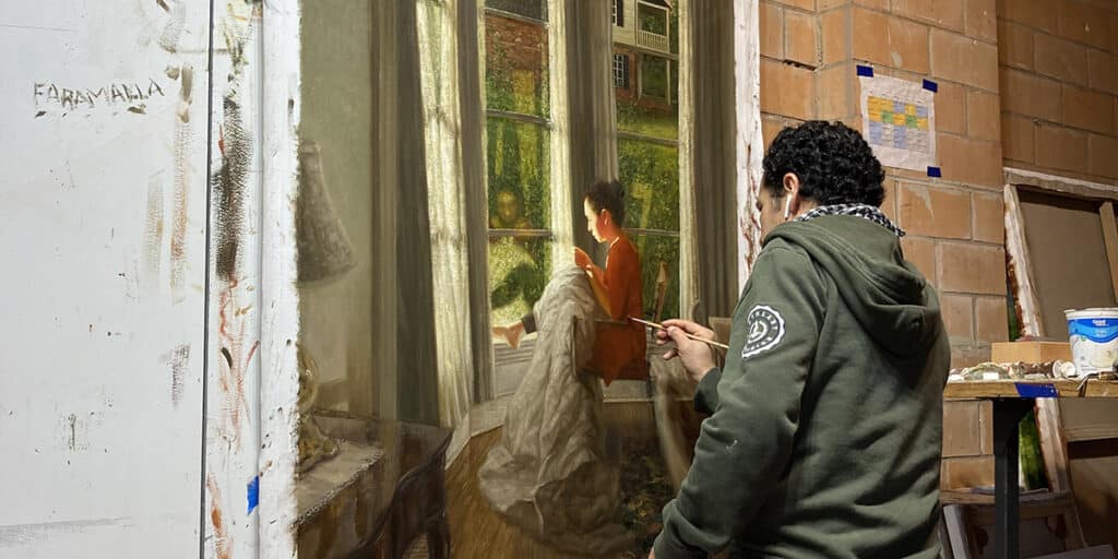 Student painting artwork of woman sewing indoors by a window