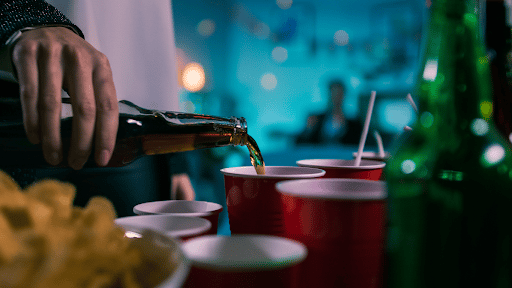 A beer being poured into a red cup.