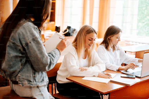 Students using laptop, studying, and taking notes